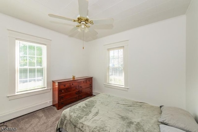 carpeted bedroom with a baseboard radiator, a ceiling fan, and multiple windows
