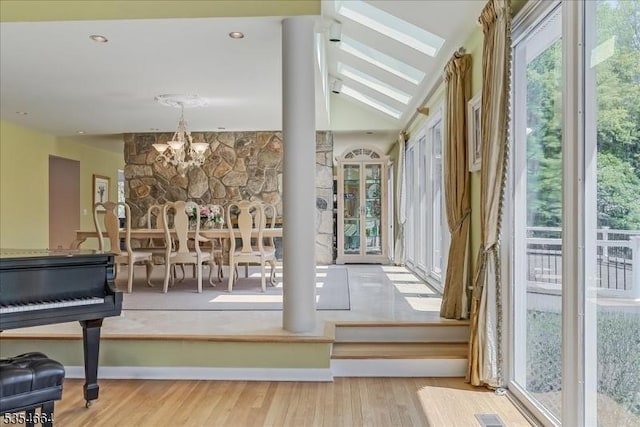 interior space with lofted ceiling with beams, an inviting chandelier, and wood finished floors