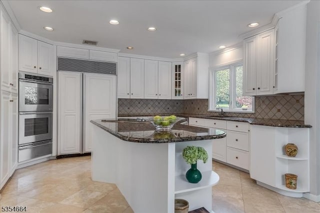 kitchen featuring stainless steel double oven, white cabinetry, open shelves, a warming drawer, and paneled refrigerator