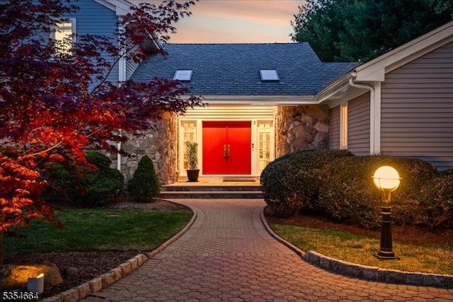 exterior entry at dusk with stone siding