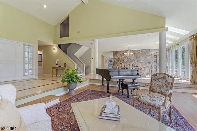 interior space with an inviting chandelier, stairs, high vaulted ceiling, and wood finished floors