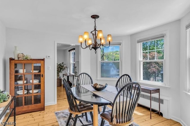 dining area featuring light wood-type flooring, baseboards, a chandelier, and a healthy amount of sunlight