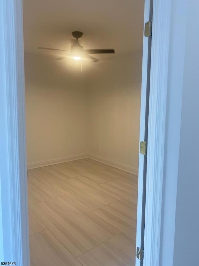empty room with ceiling fan and baseboards