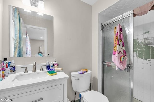 full bathroom featuring toilet, a shower stall, and vanity