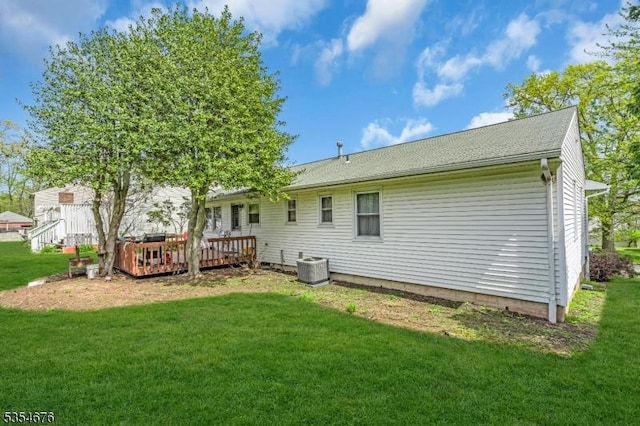 rear view of house featuring a lawn, a deck, and cooling unit