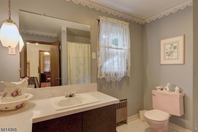 bathroom featuring tile patterned floors, baseboards, vanity, toilet, and radiator