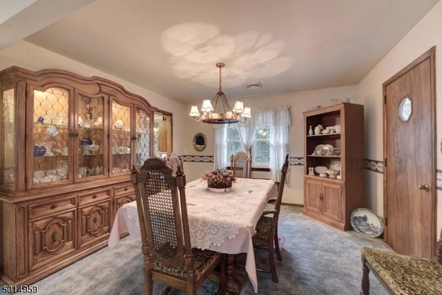 dining space featuring carpet flooring and a notable chandelier