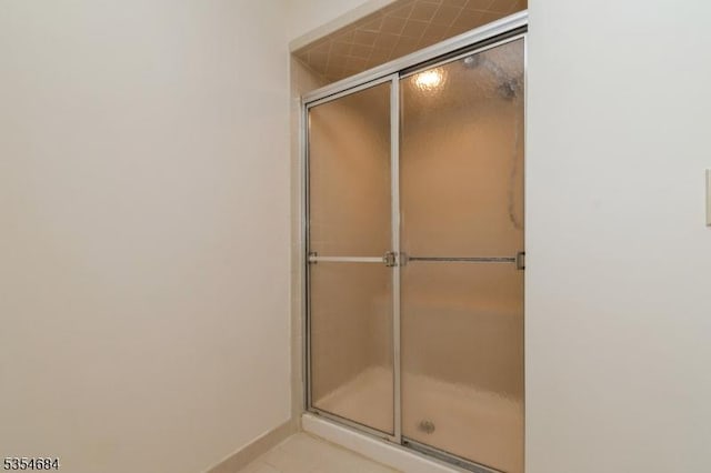 full bathroom with baseboards and a shower with door