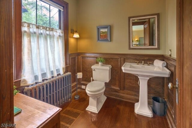 1 Ambar Pl, Bernardsville Boro, NJ 07924 - bathroom featuring radiator heating unit, a wainscoted wall, wood finished floors, and toilet