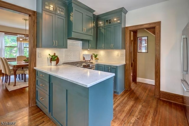 1 Ambar Pl, Bernardsville Boro, NJ 07924 - kitchen featuring dark wood-type flooring, tasteful backsplash, glass insert cabinets, baseboards, and a peninsula