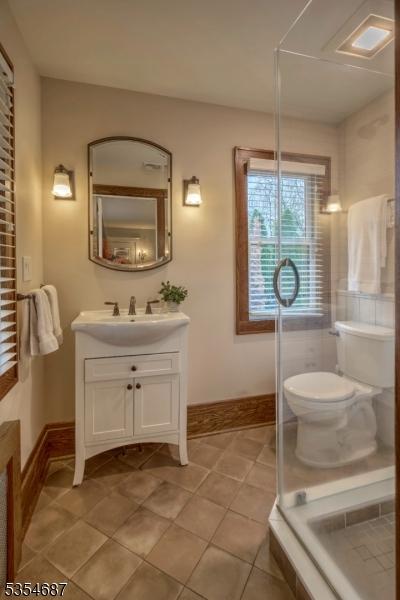 1 Ambar Pl, Bernardsville Boro, NJ 07924 - bathroom featuring tile patterned floors, baseboards, vanity, toilet, and a shower with shower door