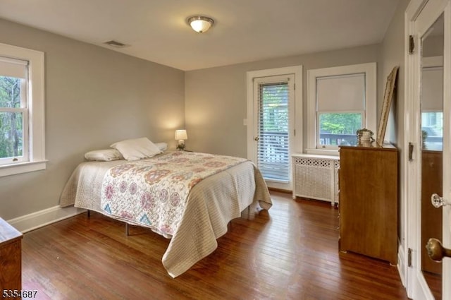 1 Ambar Pl, Bernardsville Boro, NJ 07924 - bedroom featuring radiator, multiple windows, dark wood-type flooring, and access to exterior