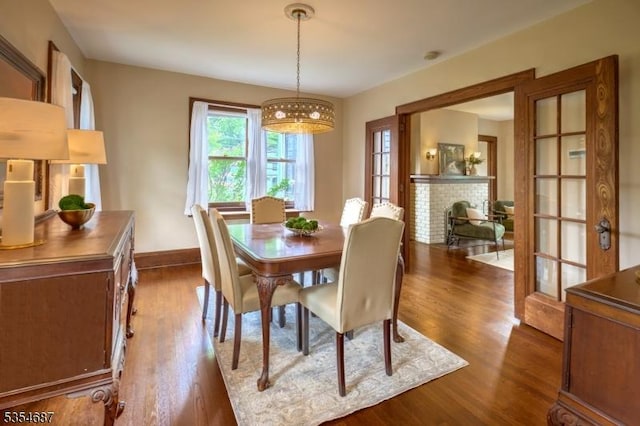 1 Ambar Pl, Bernardsville Boro, NJ 07924 - dining space with dark wood finished floors, a chandelier, baseboards, and a fireplace