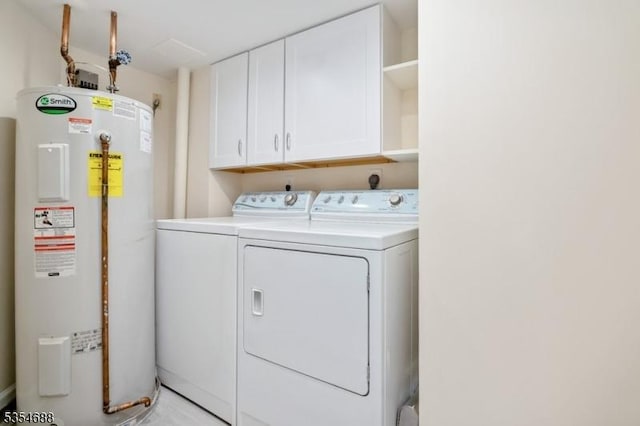 laundry room with cabinet space, water heater, and washer and dryer