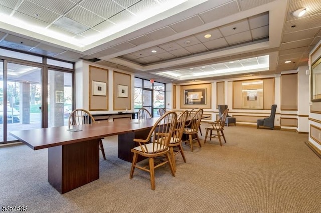 office area with light carpet and a tray ceiling
