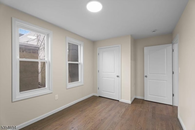 interior space with baseboards and wood finished floors
