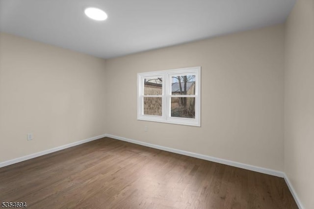 unfurnished room featuring wood finished floors and baseboards