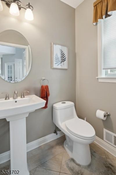 bathroom with toilet, baseboards, visible vents, and tile patterned flooring