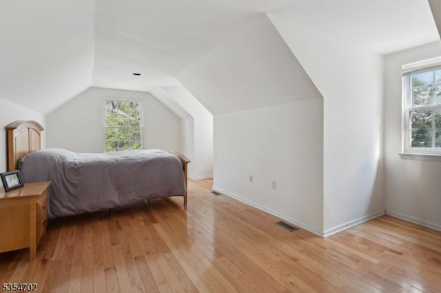 bedroom featuring light wood-type flooring, visible vents, and multiple windows