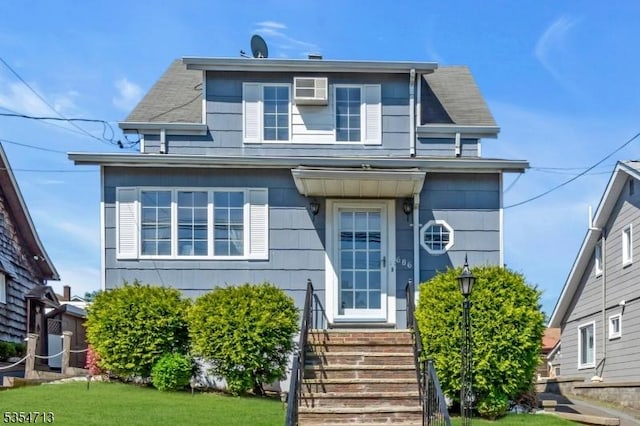bungalow with a shingled roof, a front yard, and entry steps