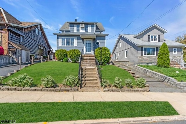 view of front of house featuring stairs and a front yard