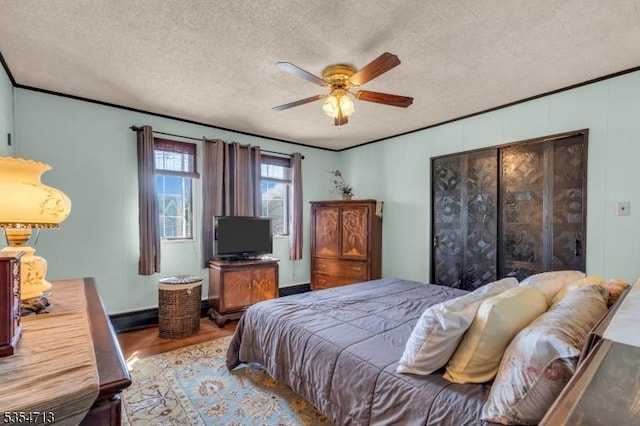 bedroom with a textured ceiling, ceiling fan, and wood finished floors