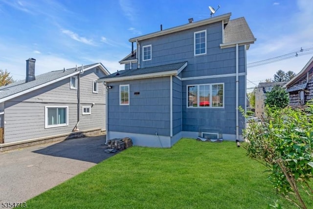 rear view of property with a yard