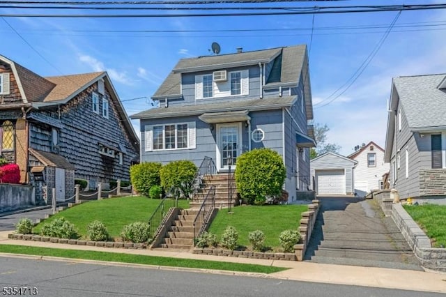 view of front facade featuring driveway, an outdoor structure, a front yard, and a garage