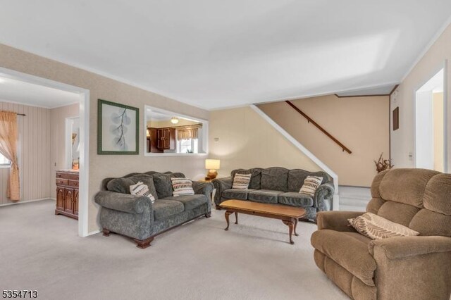 carpeted living area with plenty of natural light and stairway