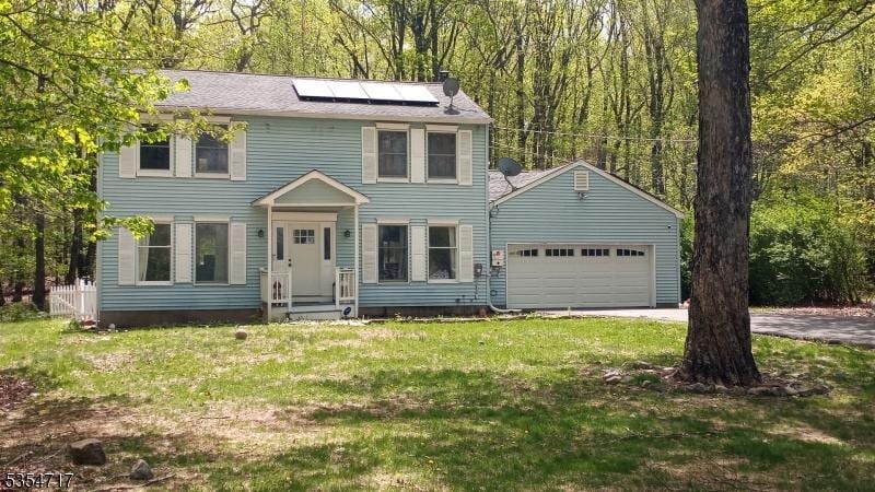57 Quenby Mountain Rd, Liberty Twp, NJ 07838 - colonial house featuring an attached garage, roof mounted solar panels, driveway, and a front yard