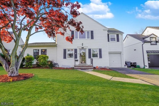 colonial home with a garage, a front lawn, and aphalt driveway