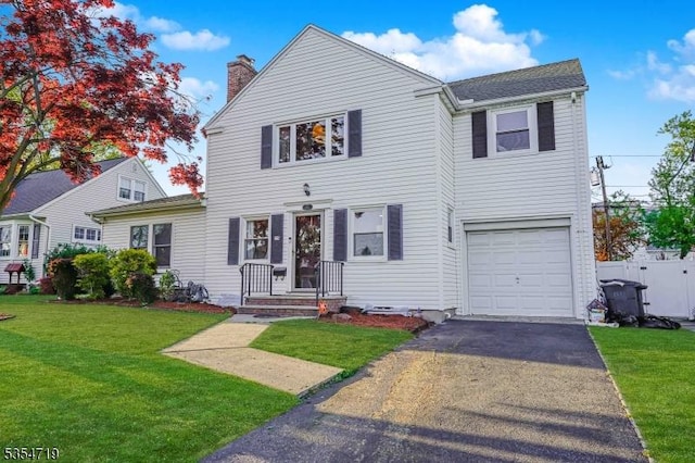 view of front of home with aphalt driveway, a chimney, a front lawn, and a garage
