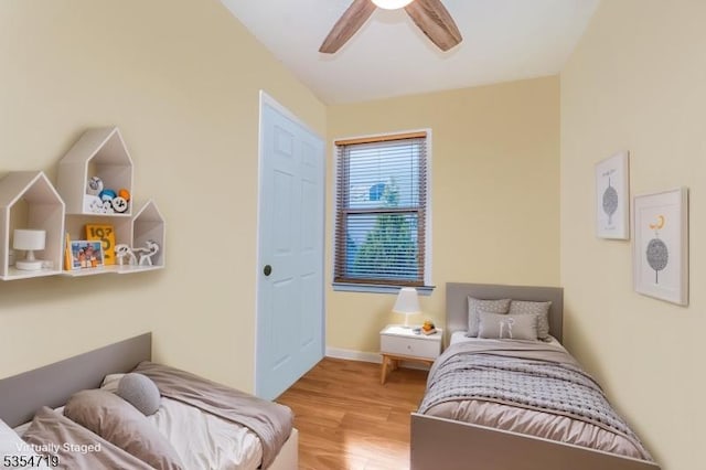 bedroom with baseboards, a ceiling fan, and wood finished floors