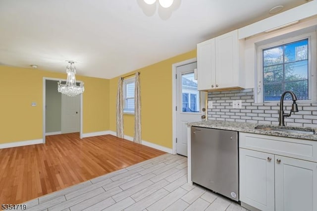 kitchen with a notable chandelier, a sink, light wood-style floors, dishwasher, and baseboards