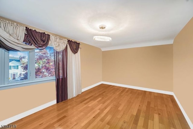 empty room featuring baseboards and light wood finished floors