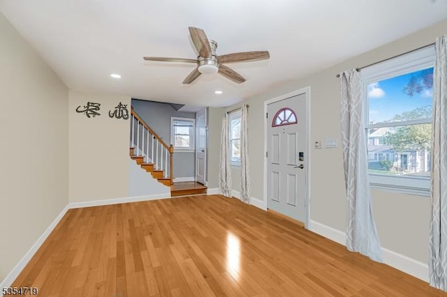 foyer entrance with light wood-style floors, baseboards, stairway, and recessed lighting
