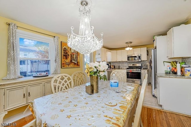 dining room featuring an inviting chandelier and light wood finished floors