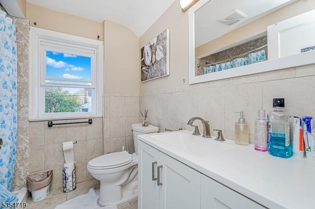full bath with vanity, toilet, a shower with shower curtain, tile walls, and visible vents
