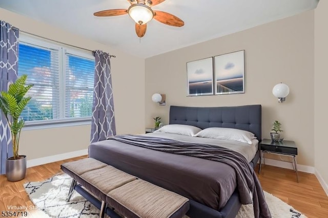 bedroom with a ceiling fan, baseboards, and wood finished floors