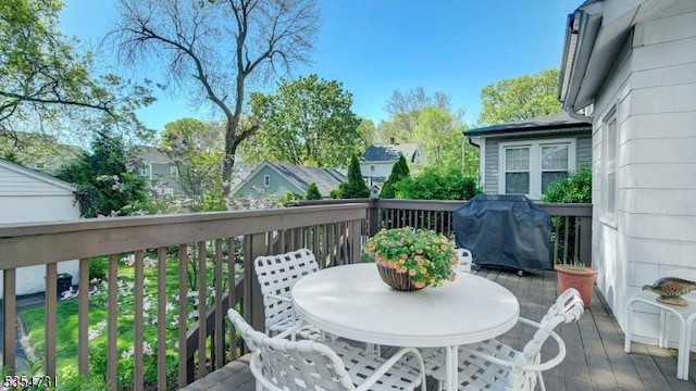 wooden deck with grilling area and outdoor dining space