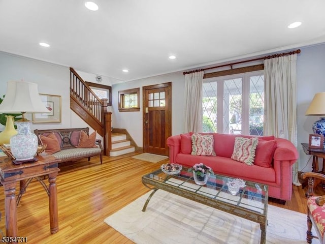 living room featuring ornamental molding, stairs, and wood finished floors