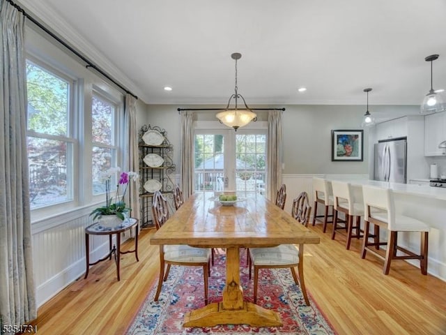 dining room featuring ornamental molding and light wood-type flooring