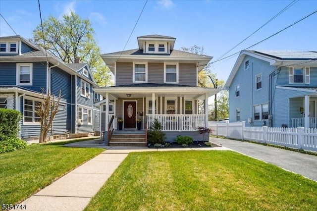 traditional style home featuring fence, covered porch, and a front yard