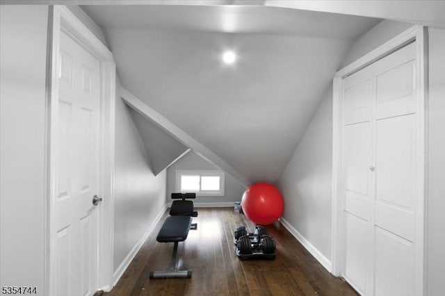 workout area with baseboards, lofted ceiling, and hardwood / wood-style floors