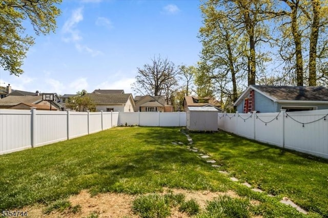 view of yard with a fenced backyard, an outdoor structure, and a storage shed