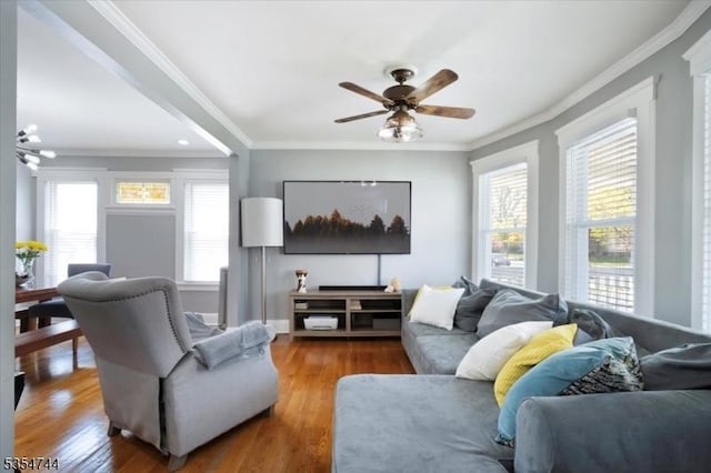 living room with a ceiling fan, ornamental molding, and a wealth of natural light