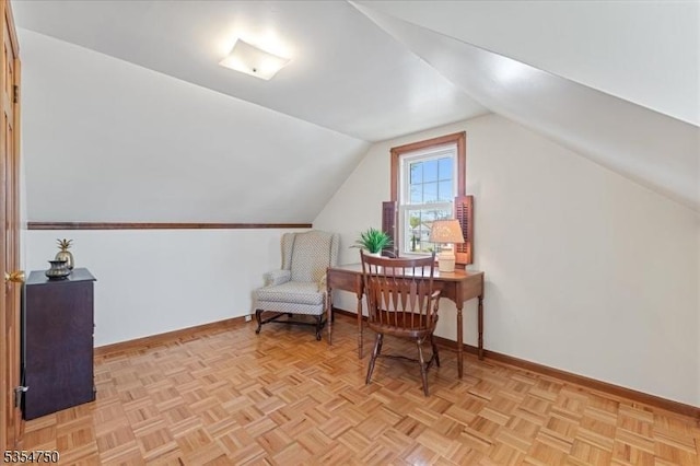 living area featuring baseboards and vaulted ceiling