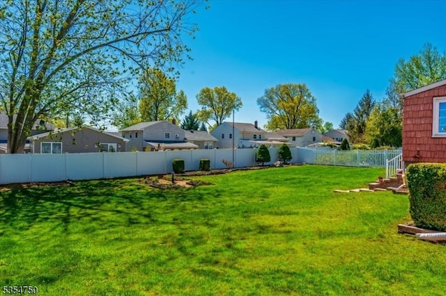 view of yard featuring a fenced backyard and a residential view