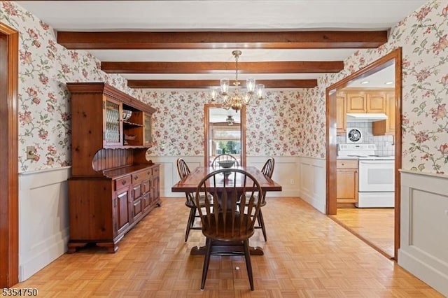 dining space with an inviting chandelier, wainscoting, and wallpapered walls