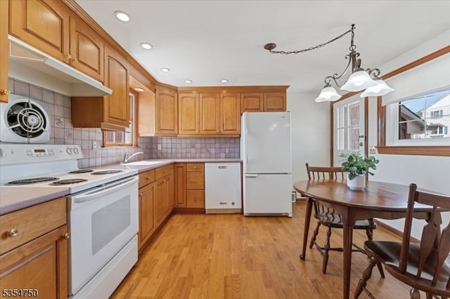 kitchen with white appliances, light wood-type flooring, tasteful backsplash, and light countertops